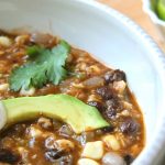 Black bean soup with corn, tomatillos, and topped with slices of avocado.