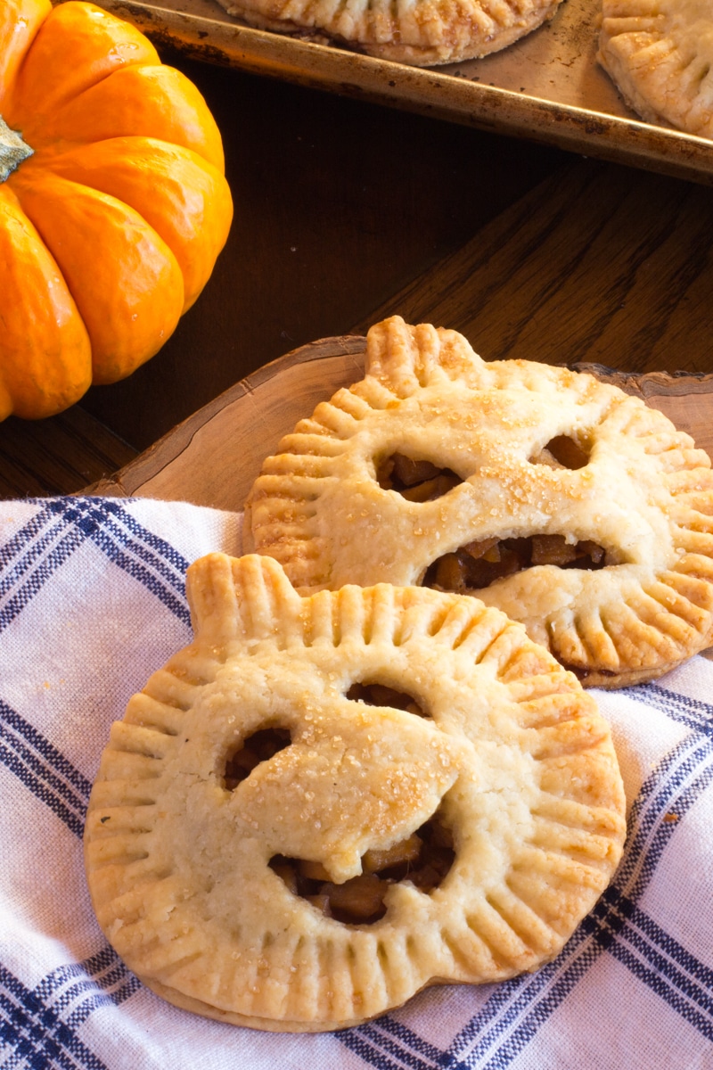 Pumpkin-shaped hand pies filled with apples, ginger, cinnamon and cardamom. Perfect kids treat for Halloween.