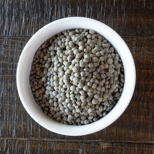 A ramekin filled with French green lentils.