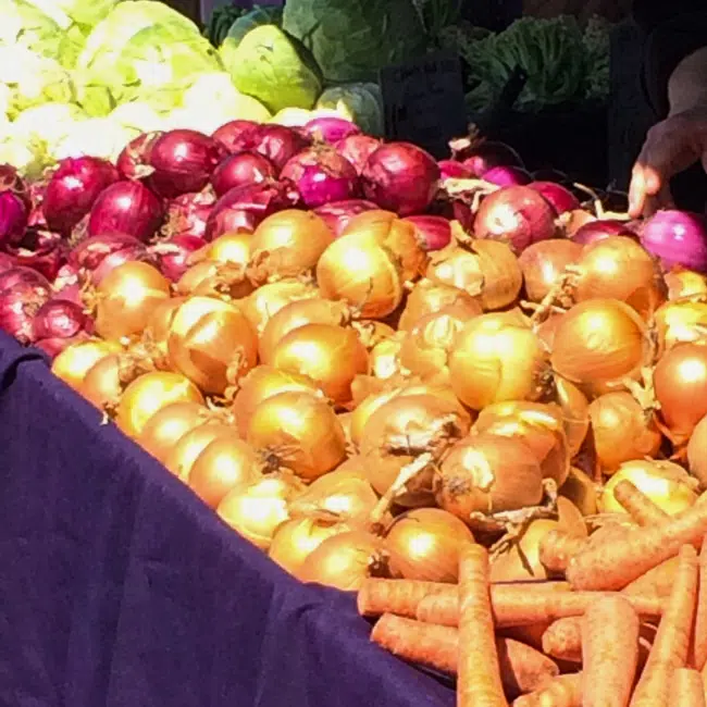 Red and yellow onions at a farmers market.
