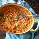Curry dinner of chickpeas, sweet potatoes, tomatoes and coconut milk in a Le Creuset pot.