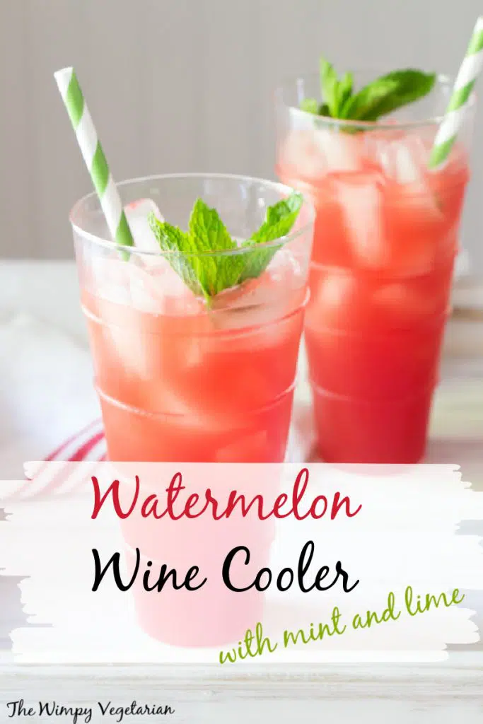 Watermelon wine cooler poured over ice in 2 glasses with sprigs of mint and straws.