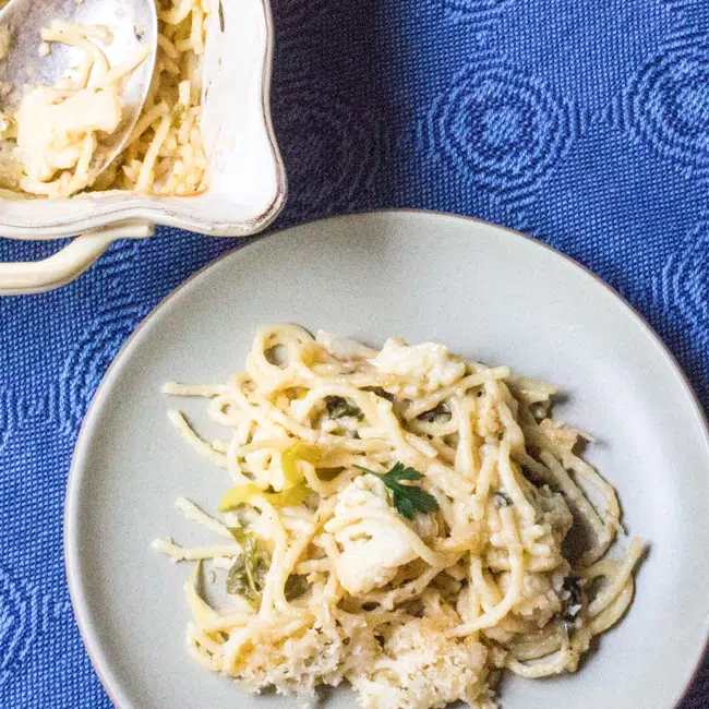 Cauliflower tetrazzini on a plate dotted with roasted poblano peppers.