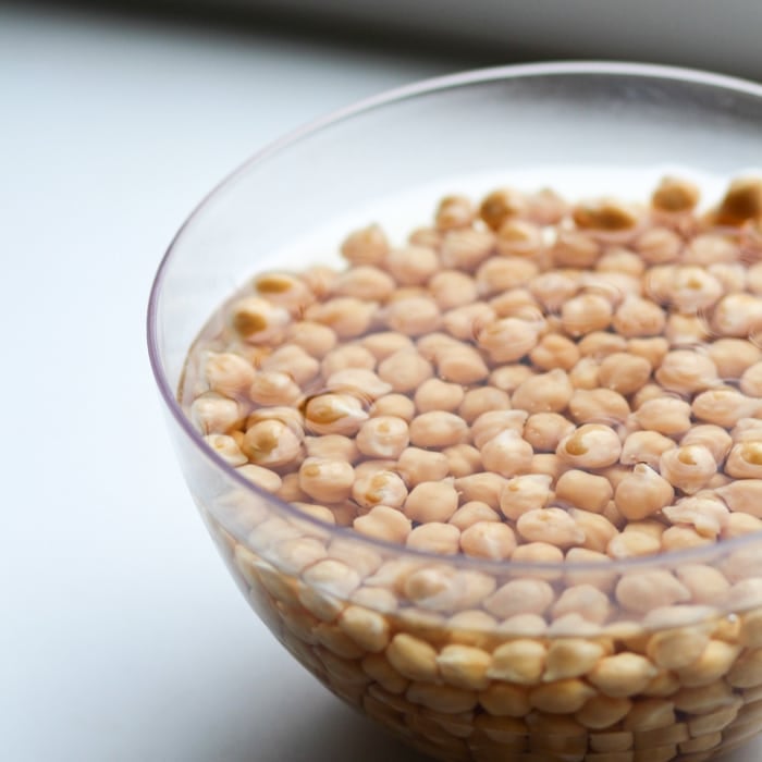 A bowl of chickpeas soaking in water.