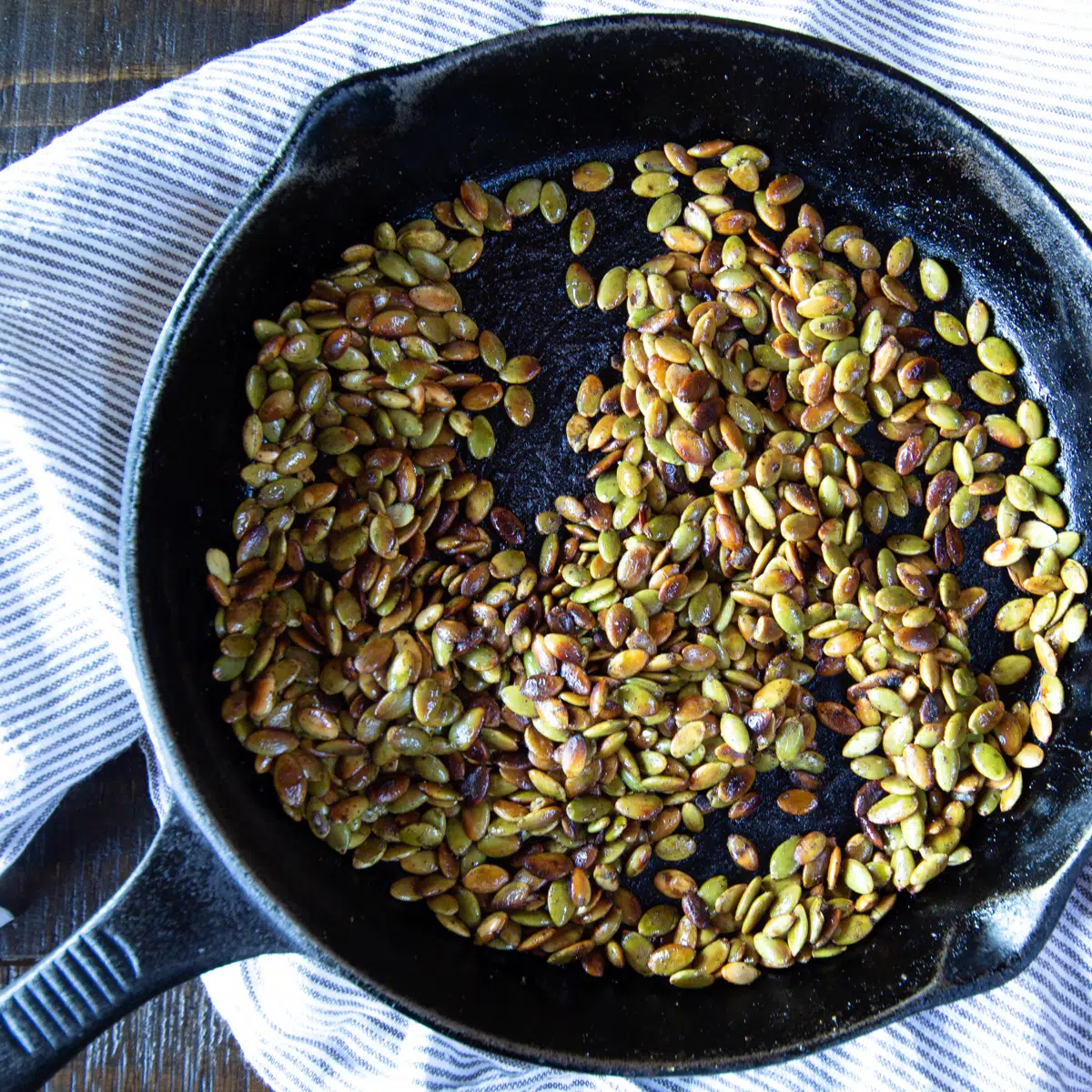Roasted pumpkin seeds in a cast iron skillet.