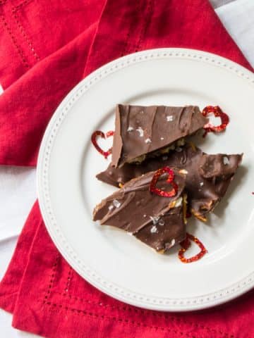 Pieces of chocolate bark with pretzels and sea salt on a plate.