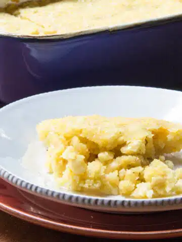 A plate of tomalito sweet cornbread, with the casserole in the background.