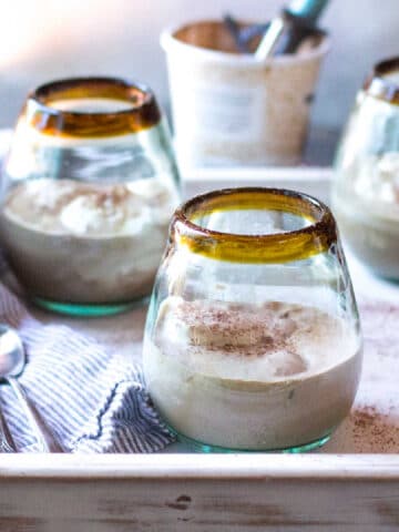 Glasses of Frozen Mudslides on a tray, with an ice cream carton in the background.