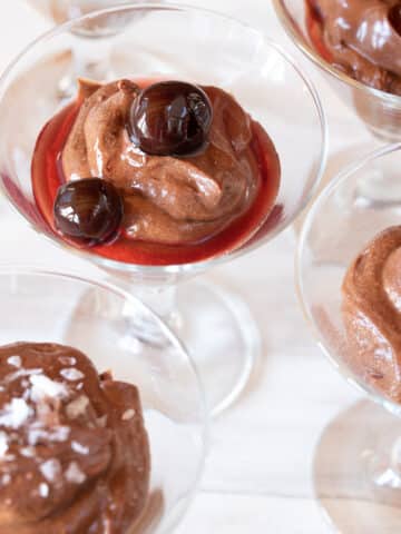 Small glasses filled with Bailey's Chocolate Mousse with different toppings: cherries, nuts, and salt.
