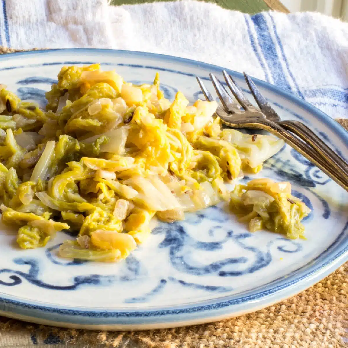 Braised cabbage on a plate with two small forks.