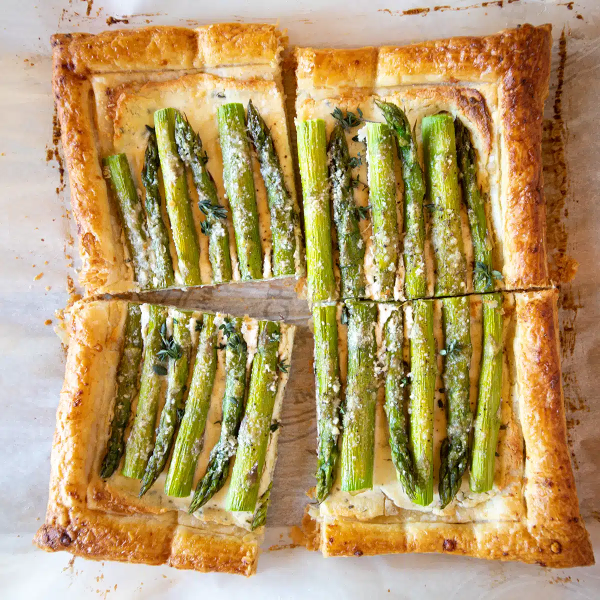 Asparagus tart baked in puff pastry with cheese, sliced into 4 pieces.