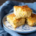 Three pieces of mexican cornbread stacked on top of each other, with one broken up a little.