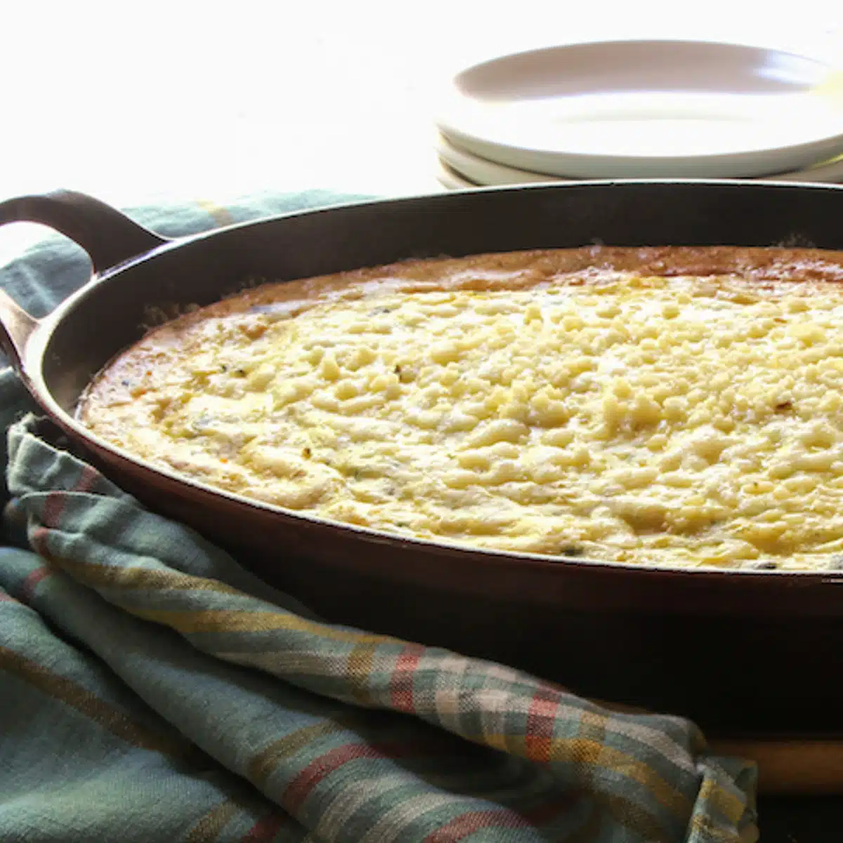 Corn pudding baked in a skillet, ready to serve.