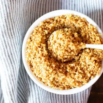 A small bowl of crispy quinoa with a spoon.