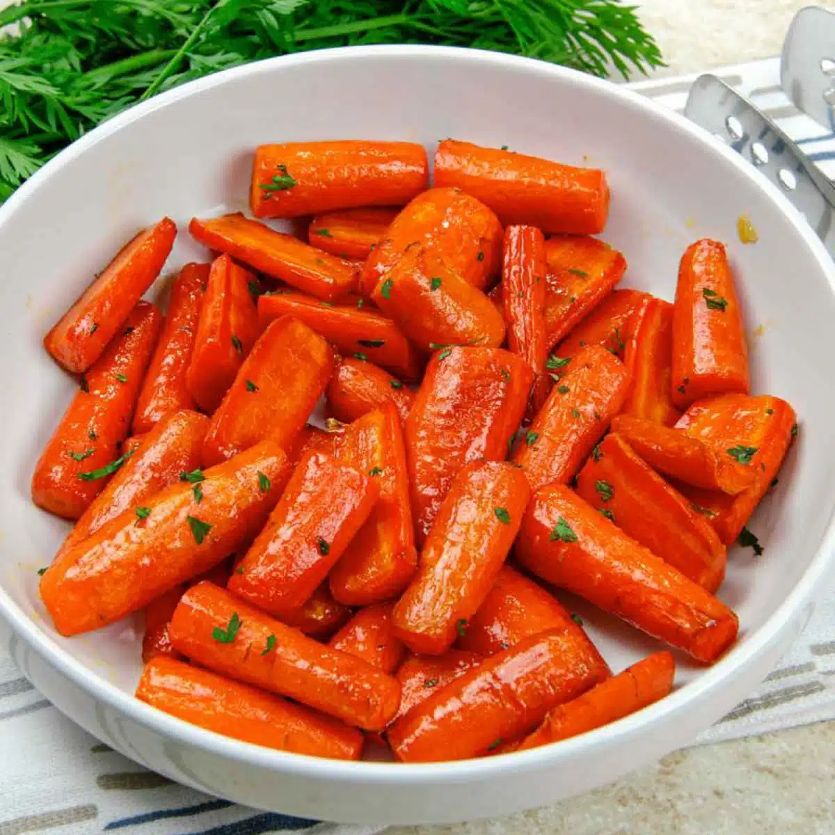 A bowl of honey brown sugar glazed carrots with a little parsley.
