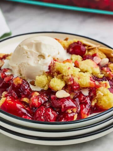 A serving of dump cake with a scoop of ice cream on a saucer.