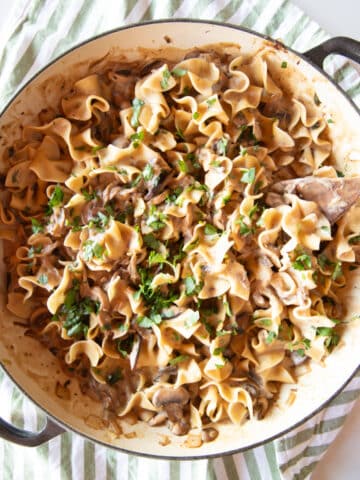 A wide pan filled with creamy mushroom stroganoff topped with a little parsley.